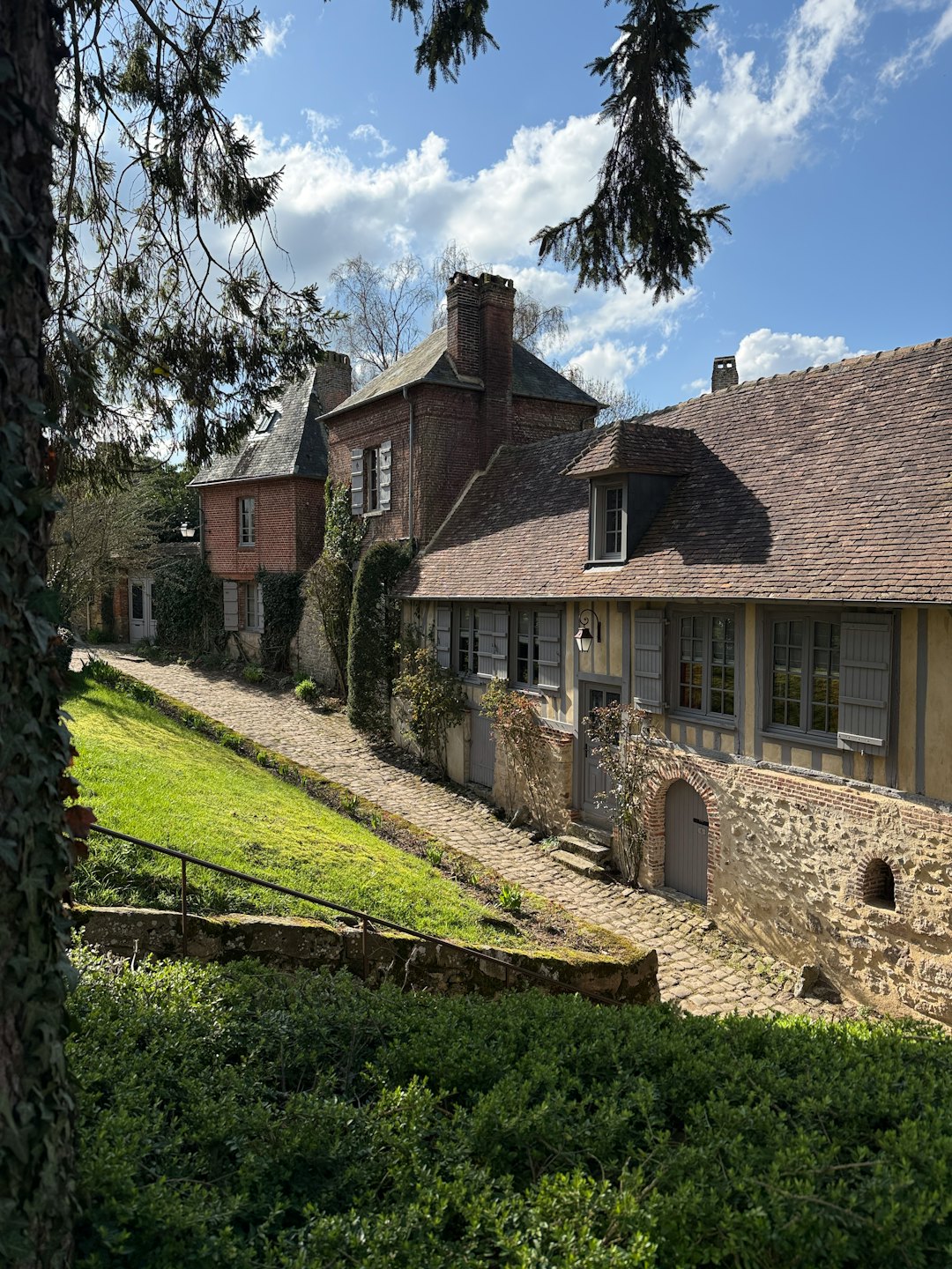 Historic brick and stone buildings sit along a winding path.